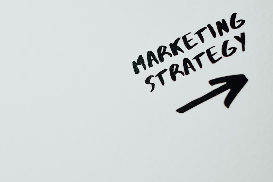pexels-photo-7661068-7661068 Close-up of handwritten 'Marketing Strategy' text with an arrow on white background.